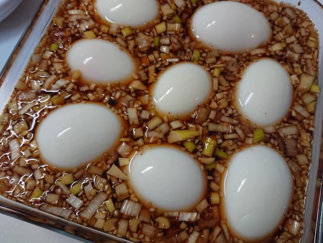 ゆで卵の醤油漬けの作り方。ネギだれにゆで卵を入れる（韓国の麻薬卵）